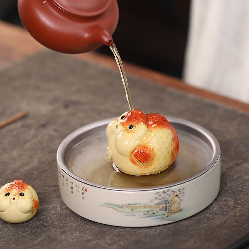 A cute and fun tea toy and tea pet featuring a small purple clay goldfish sputting bubbles, an incense tray, and a tea table decoration