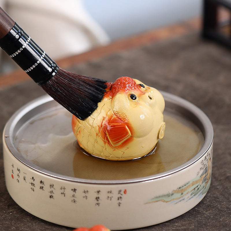 A cute and fun tea toy and tea pet featuring a small purple clay goldfish sputting bubbles, an incense tray, and a tea table decoration