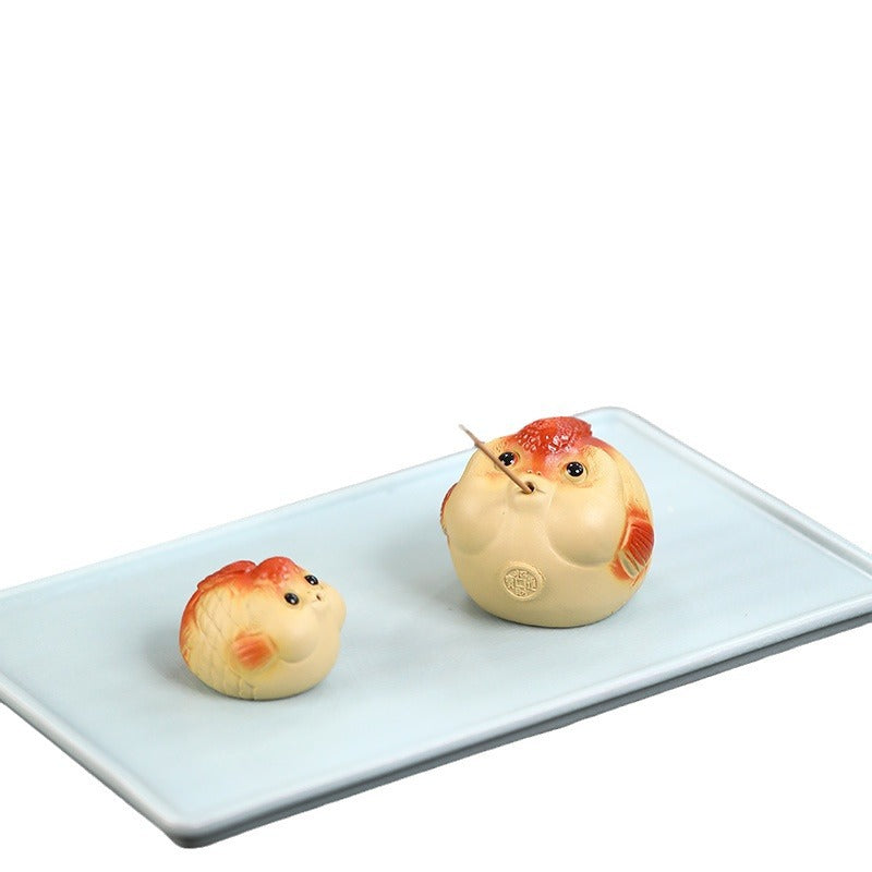 A cute and fun tea toy and tea pet featuring a small purple clay goldfish sputting bubbles, an incense tray, and a tea table decoration