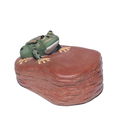 A handcrafted, creative and personalized tea set accessory made of Yixing purple clay, featuring a ceramic tea pet and a water-spraying frog stone figurine