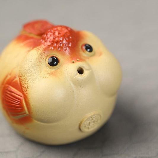 A cute and fun tea toy and tea pet featuring a small purple clay goldfish sputting bubbles, an incense tray, and a tea table decoration